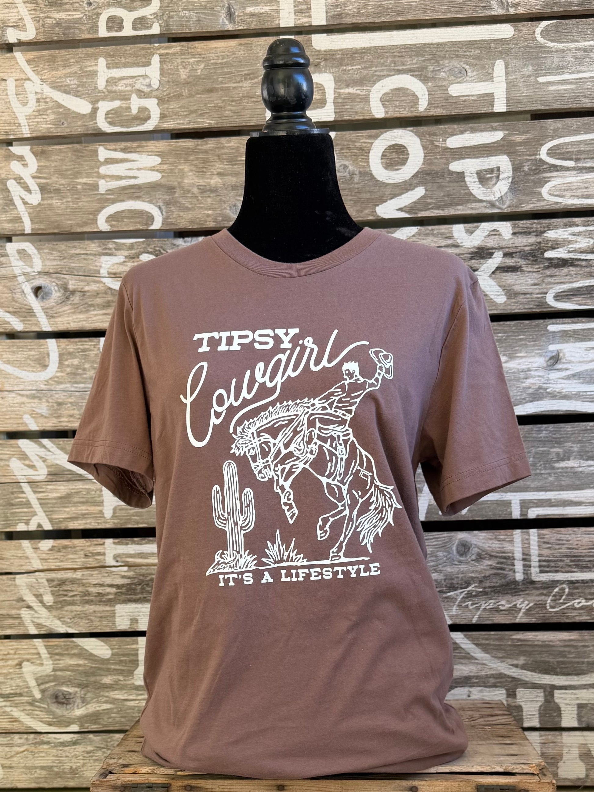 Tipsy Cowgirl Lifestyle Pebble Brown western T-shirt with white bucking bronc graphic